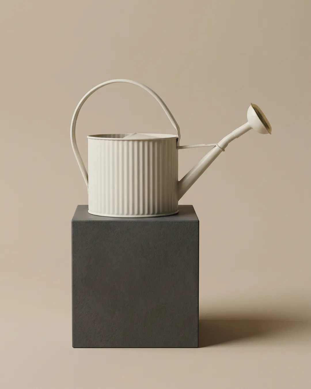 Petit arrosoir beige 1,75L Guillouard avec anse ergonomique et pomme à grille en laiton présenté sur un socle foncé